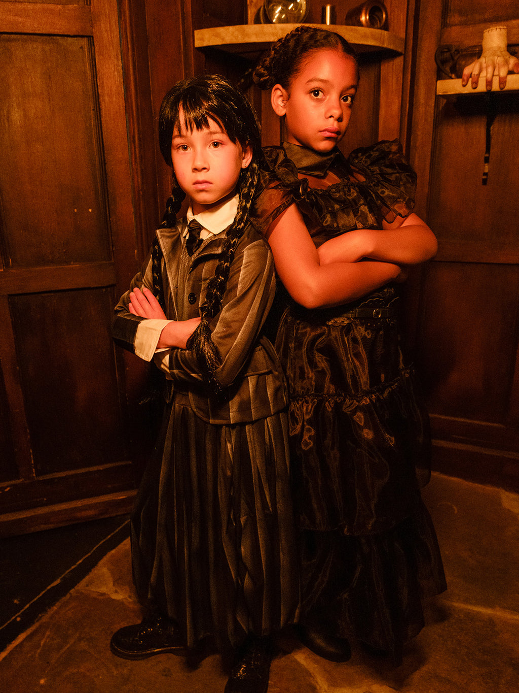 Girl in the Nevermore Academy uniform with arms folded, standing back to back with a friend