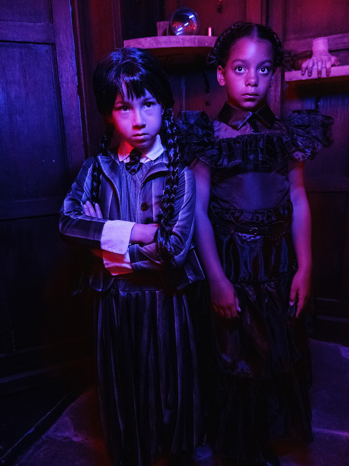 Girl in the Nevermore Academy striped jacket and pleated skirt under purple lighting
