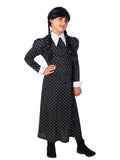 Girl wearing a long black Wednesday dress with puffed shoulders, white collar and cuffs and printed flowers