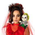 Woman in a red veil with a moulded Beetlejuice figure sitting on her shoulder
