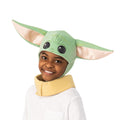 Child wearing the green Grogu headpiece with big ears and a tan collar