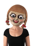 Annabelle googly eyes doll mask with red braided pigtails, worn by a woman in a black top