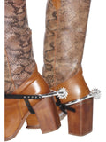 Silver cowboy spurs with black straps, worn on brown boots