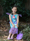 Girl sitting in Ariel dress with character-print bodice and purple tulle tail, with purple shell bag