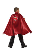 Back view of a boy wearing the long red Superman cape with logo