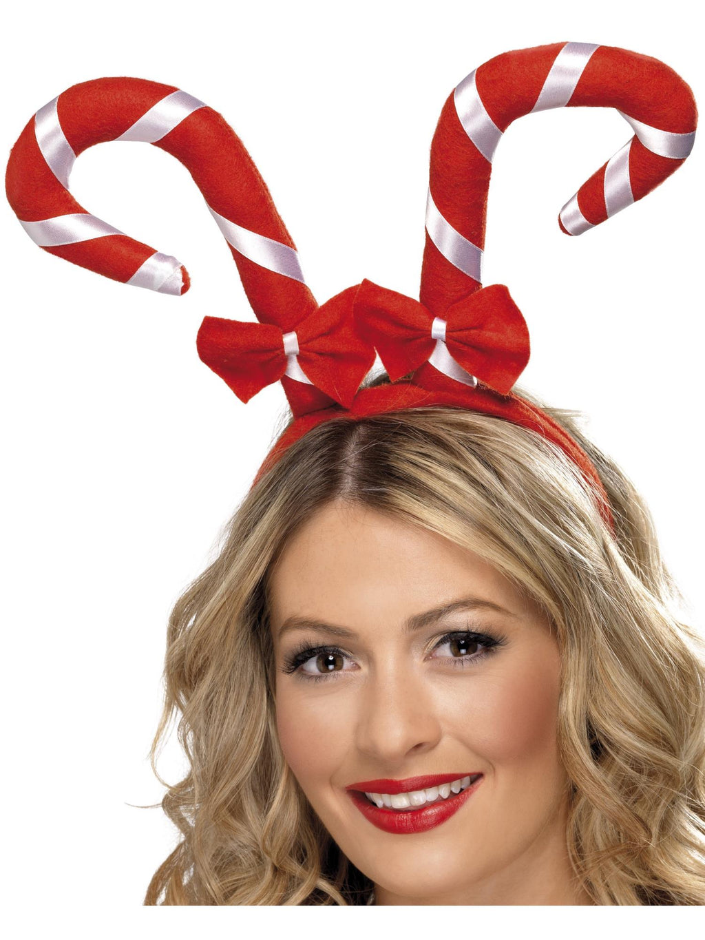 Woman wearing a headband with two red and white striped candy canes and red bows