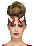 Woman wearing cream latex devil horn prosthetics on her forehead