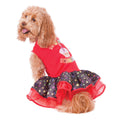 Curly-haired dog wearing the Barkday tutu dress, red top with a layered black and red candle-print skirt