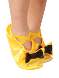 Child's feet in yellow satin Wiggles slippers with black bows