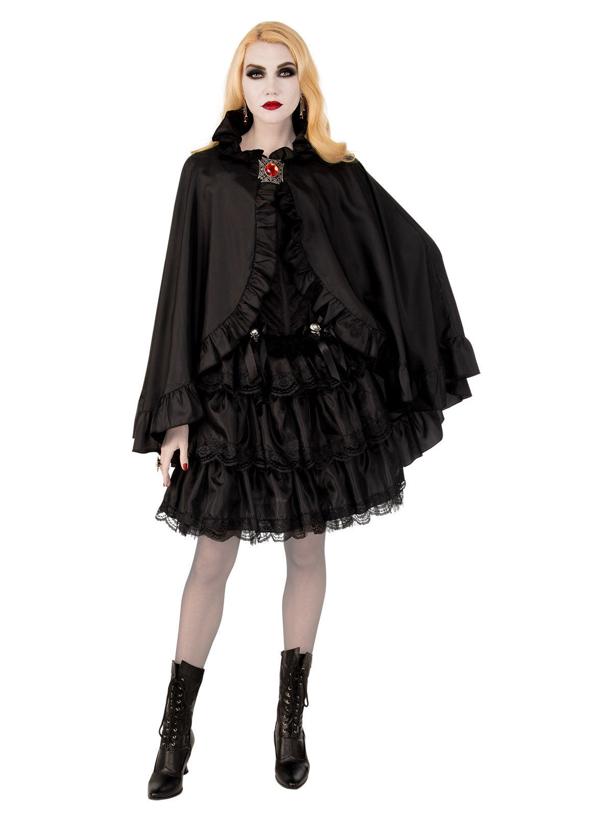 Woman wearing a short black satin cape with scalloped edge, high collar and red gem clasp