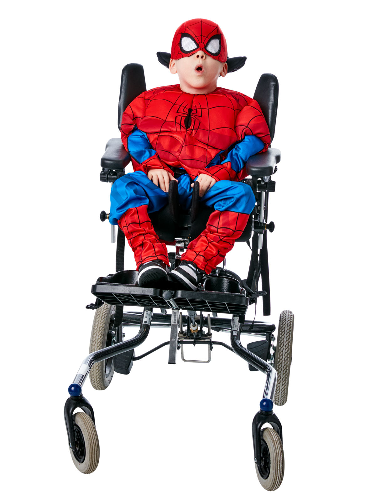 Boy using a wheelchair, wearing an adaptive Spider-Man costume with padded top, printed pants and mask