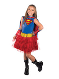 Girl wearing a Supergirl costume with blue S-logo top, red cape and red skirt