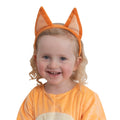 Toddler smiling in orange plush Bingo ears on a headband