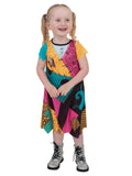 Toddler girl in the Sally Finkelstein patchwork dress with teal, orange and pink patches, standing