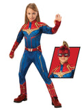 Girl in Captain Marvel hero suit jumpsuit in blue and red with gold star emblem and headpiece