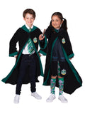 Boy and girl wearing black Slytherin hooded robes with green-lined hood and house emblem on the chest