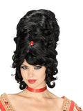 Woman wearing a tall black curly beehive wig with side fringe