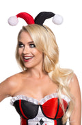 Woman wearing the red and black Harley Quinn jester headband with white pompoms